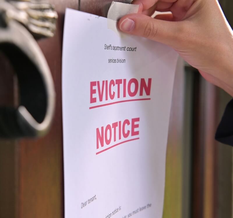 hand taping eviction notice to door